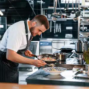 Focused on making delicious salad. Chef is on the kitchen preparing food.